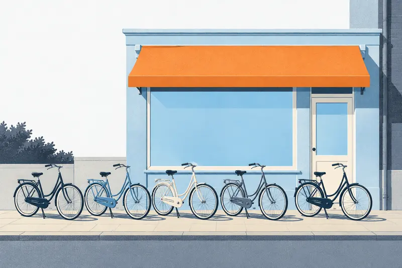 A row of town bikes on the pavement outside our shop, under an orange awning